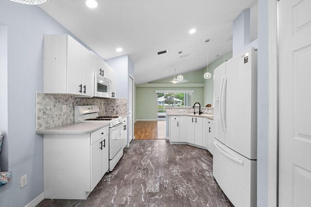 kitchen featuring white appliances, decorative backsplash, light countertops, a peninsula, and lofted ceiling