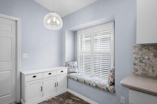 interior space featuring baseboards, a notable chandelier, and vaulted ceiling