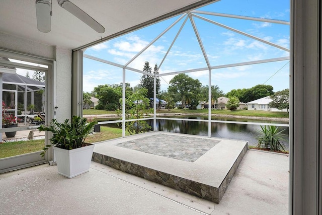sunroom featuring a ceiling fan and a water view