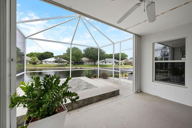 view of patio / terrace with a residential view, a ceiling fan, a water view, and glass enclosure