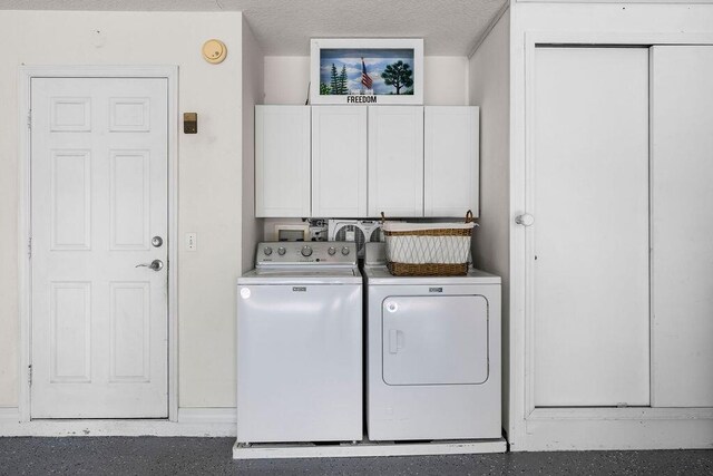 washroom featuring independent washer and dryer and cabinet space