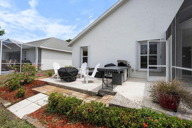 rear view of house featuring a patio, stucco siding, and a lanai