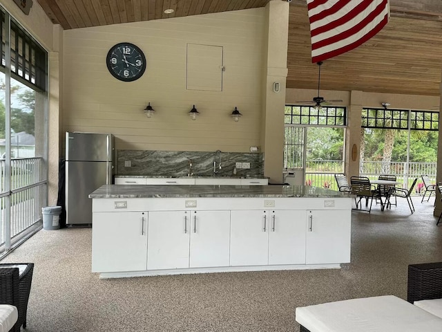 kitchen featuring wood ceiling, freestanding refrigerator, white cabinetry, a ceiling fan, and lofted ceiling