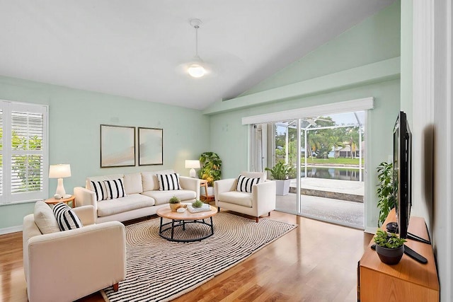 living area featuring vaulted ceiling and wood finished floors