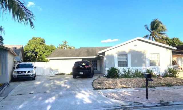 ranch-style home featuring stucco siding, a garage, and concrete driveway