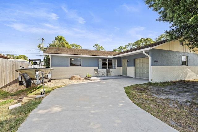1728 SE Harrison St, Stuart, FL 34997 - ranch-style house featuring a garage, fence, driveway, and brick siding