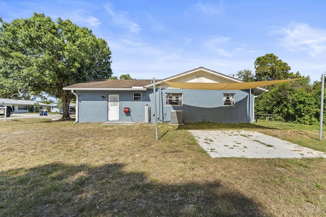 1728 SE Harrison St, Stuart, FL 34997 - rear view of property with central air condition unit and a lawn