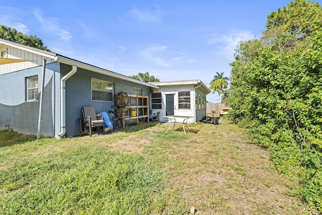 1728 SE Harrison St, Stuart, FL 34997 - back of property featuring stucco siding and a yard