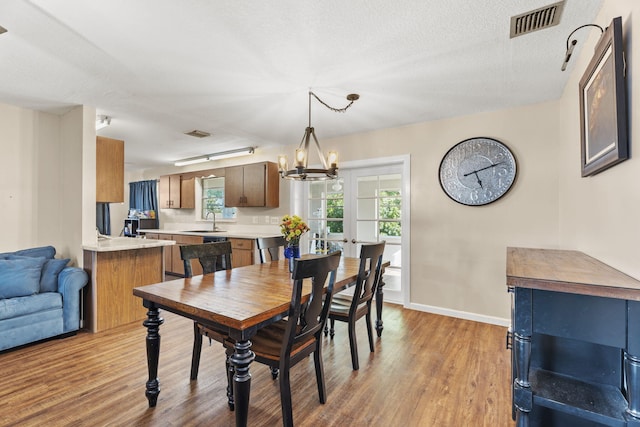 1728 SE Harrison St, Stuart, FL 34997 - dining room with visible vents, light wood-style flooring, baseboards, and a chandelier