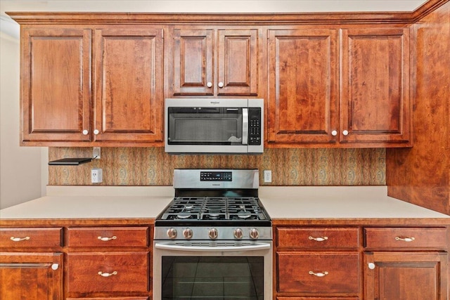 kitchen with brown cabinetry, light countertops, and appliances with stainless steel finishes