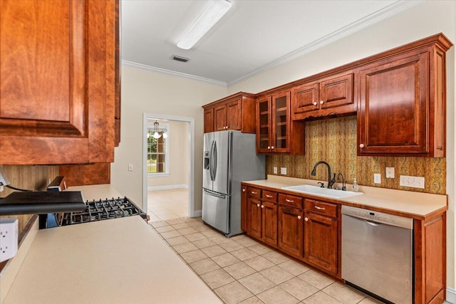 kitchen featuring crown molding, light countertops, a sink, light tile patterned floors, and stainless steel appliances