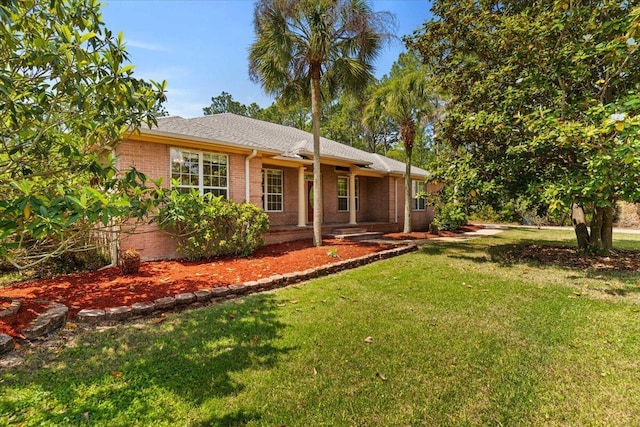 back of house with a lawn and brick siding