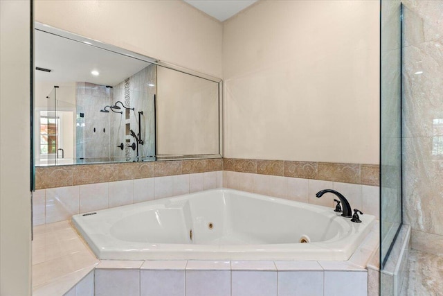 full bathroom with a jetted tub and a tile shower