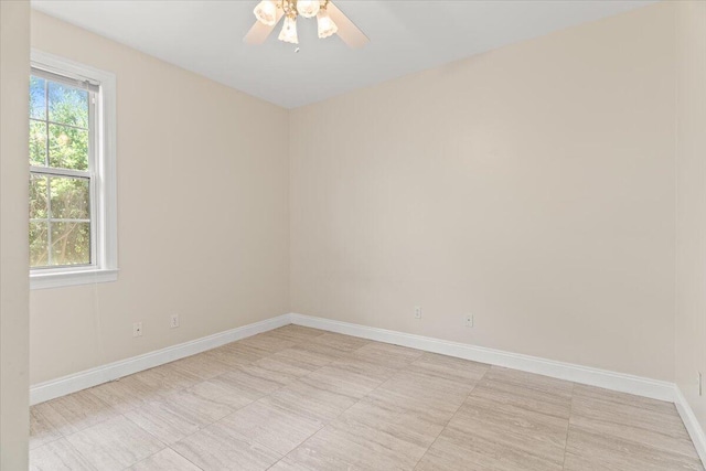 unfurnished room featuring a ceiling fan and baseboards