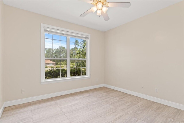 spare room with baseboards and a ceiling fan