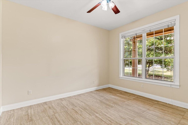 spare room with baseboards and ceiling fan