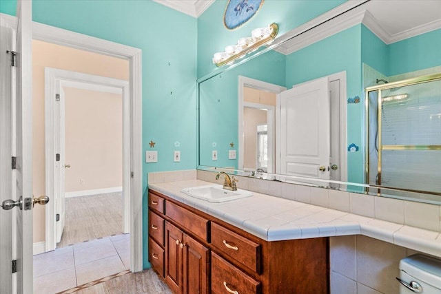 full bathroom with crown molding, vanity, a stall shower, and tile patterned floors
