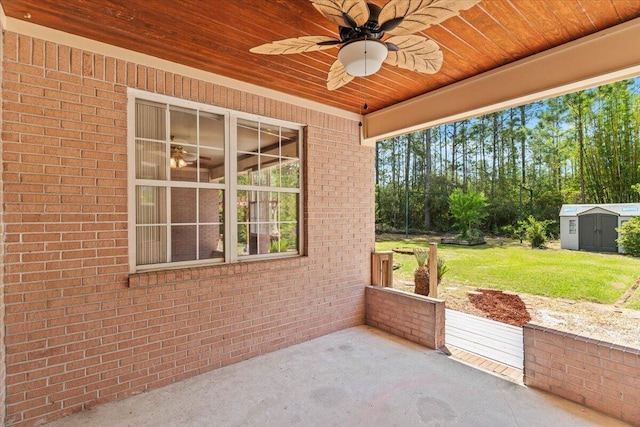 view of patio featuring an outdoor structure, ceiling fan, and a shed