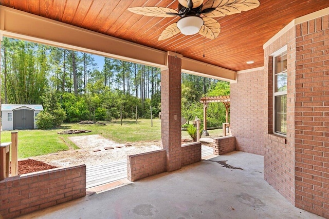 view of patio / terrace with a storage unit, an outbuilding, and a ceiling fan