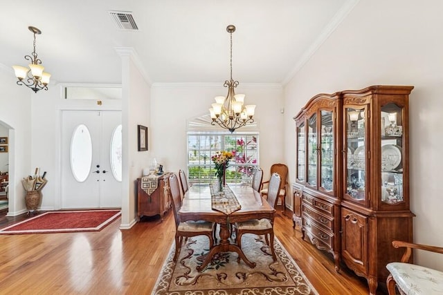 376 SW Quiet Woods, Port Saint Lucie, FL 34953 - dining room featuring visible vents, light wood-style floors, crown molding, and a notable chandelier