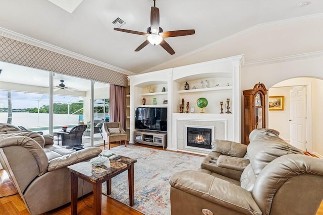 376 SW Quiet Woods, Port Saint Lucie, FL 34953 - living room with crown molding, wood finished floors, arched walkways, a ceiling fan, and vaulted ceiling