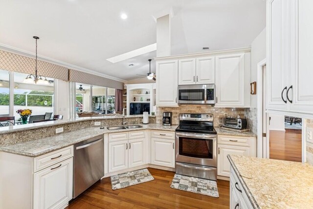376 SW Quiet Woods, Port Saint Lucie, FL 34953 - kitchen featuring crown molding, ceiling fan with notable chandelier, a sink, appliances with stainless steel finishes, and vaulted ceiling