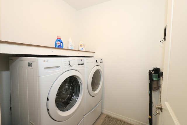 washroom with separate washer and dryer, baseboards, light tile patterned flooring, and laundry area