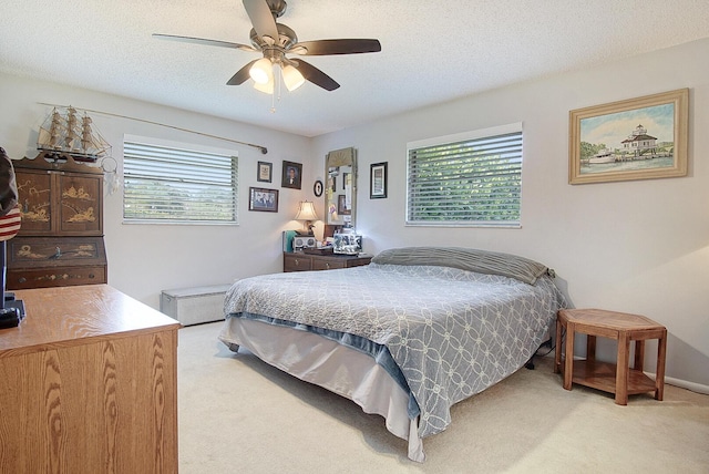 5620 SE Paramount Dr, Stuart, FL 34997 - bedroom featuring multiple windows, a ceiling fan, a textured ceiling, and light carpet