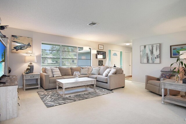 5620 SE Paramount Dr, Stuart, FL 34997 - living room featuring a textured ceiling, visible vents, light carpet, and baseboards