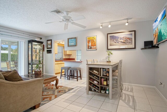 5620 SE Paramount Dr, Stuart, FL 34997 - dining room with light tile patterned floors, ceiling fan, baseboards, and a textured ceiling
