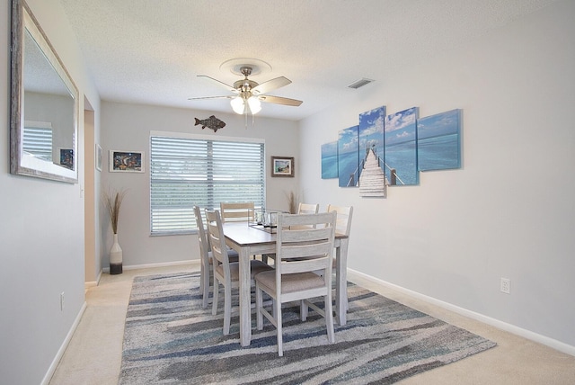5620 SE Paramount Dr, Stuart, FL 34997 - carpeted dining room with a textured ceiling, visible vents, ceiling fan, and baseboards