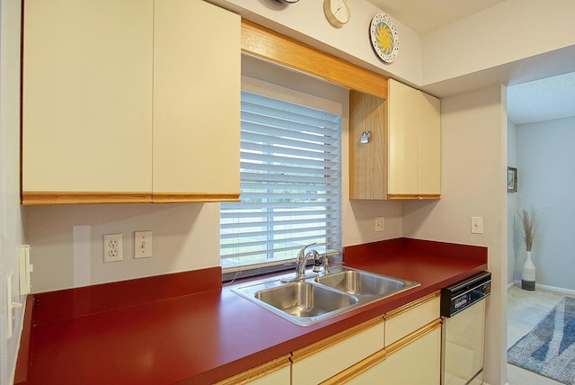 5620 SE Paramount Dr, Stuart, FL 34997 - kitchen featuring dark countertops, dishwasher, carpet flooring, a sink, and cream cabinetry