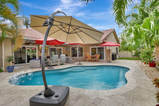 view of swimming pool featuring outdoor dining area, ceiling fan, a fenced in pool, and a patio