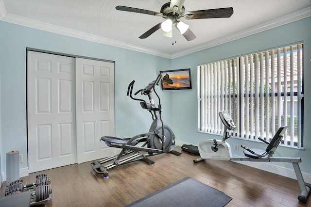 workout area with crown molding, baseboards, ceiling fan, and wood finished floors