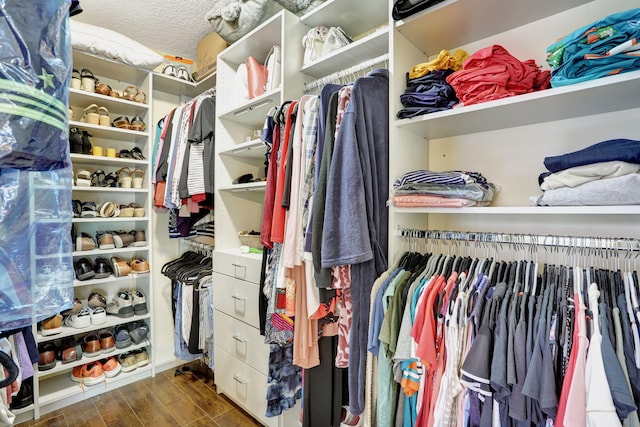 walk in closet with wood finished floors