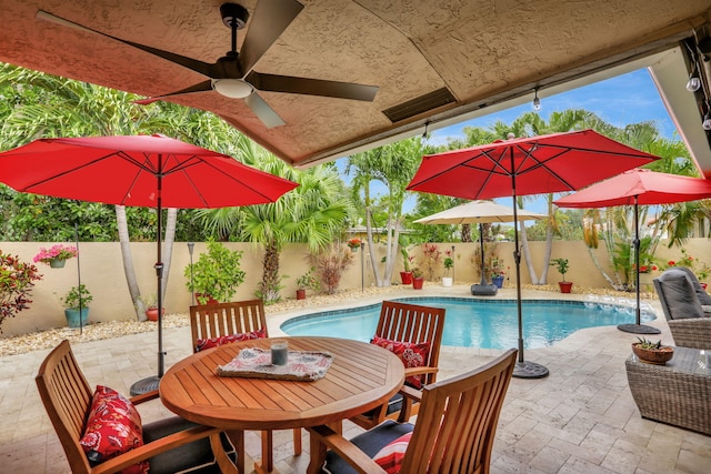 view of pool with ceiling fan, outdoor dining area, a fenced backyard, a fenced in pool, and a patio area