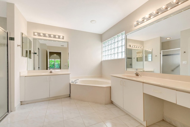 bathroom with a stall shower, a garden tub, a sink, and a healthy amount of sunlight