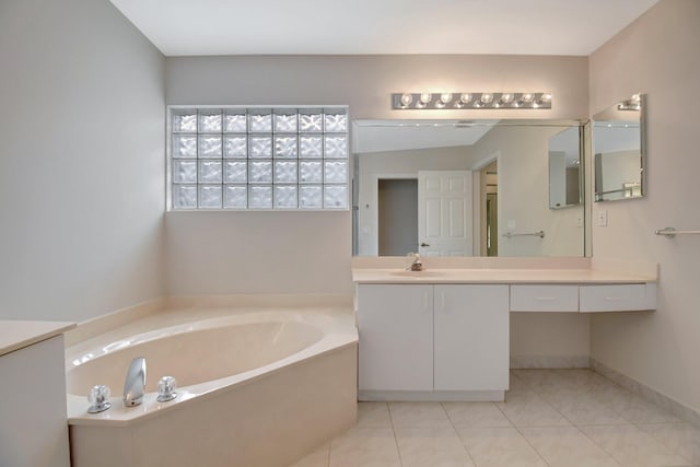 full bath with a garden tub, vanity, tile patterned floors, and baseboards