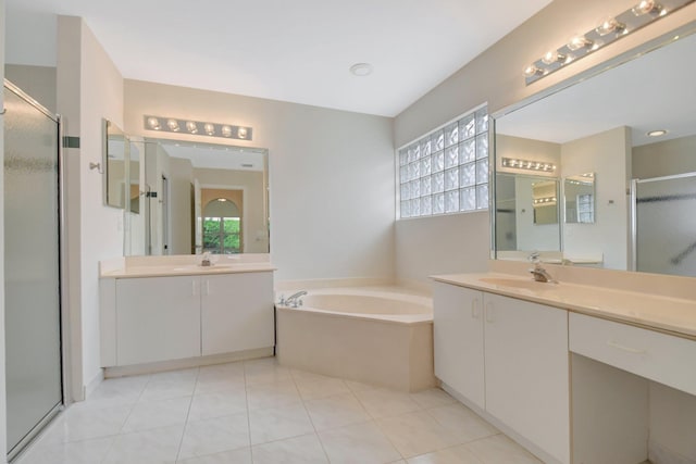 full bath with two vanities, a bath, a stall shower, and a sink