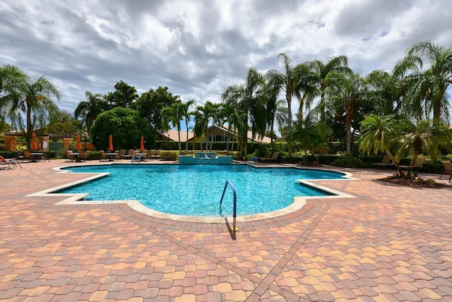 view of pool with a pool with connected hot tub and a patio