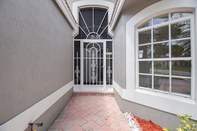 doorway to property featuring stucco siding
