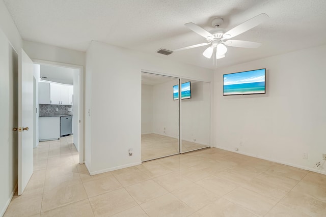 6209 Pond Tree Ct, Greenacres, FL 33463 - unfurnished bedroom with a textured ceiling, a ceiling fan, a closet, light tile patterned floors, and baseboards