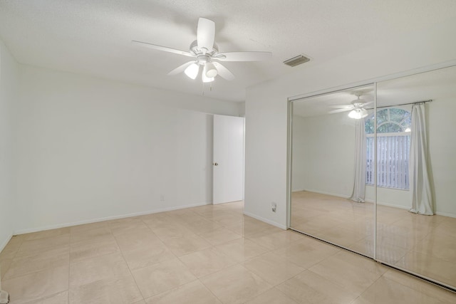 6209 Pond Tree Ct, Greenacres, FL 33463 - unfurnished bedroom with a closet, ceiling fan, a textured ceiling, baseboards, and light tile patterned floors