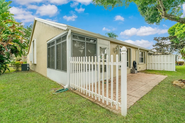 6209 Pond Tree Ct, Greenacres, FL 33463 - rear view of property with a sunroom, central AC, stucco siding, and a patio