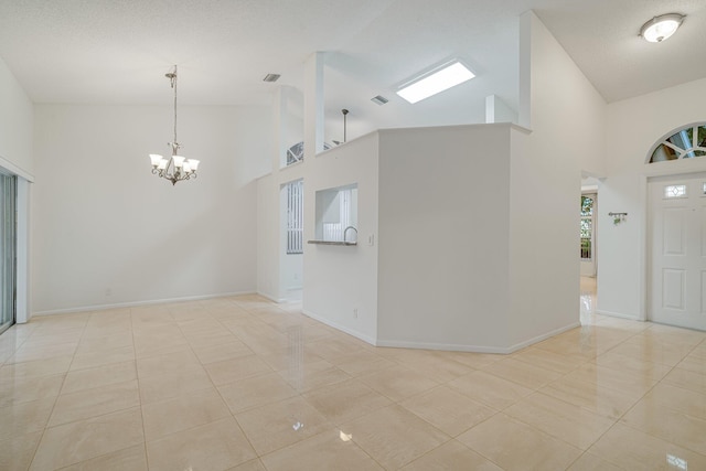6209 Pond Tree Ct, Greenacres, FL 33463 - foyer entrance with high vaulted ceiling, a chandelier, light tile patterned floors, and baseboards