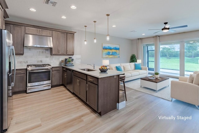 13509 SW Oceanus Blvd, Port Saint Lucie, FL 34987 - kitchen with stainless steel appliances, under cabinet range hood, open floor plan, a sink, and recessed lighting