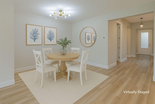 13509 SW Oceanus Blvd, Port Saint Lucie, FL 34987 - dining area with a chandelier, light wood-type flooring, and baseboards