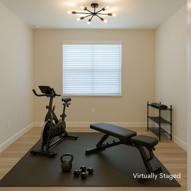 13509 SW Oceanus Blvd, Port Saint Lucie, FL 34987 - exercise room with light wood-style floors, baseboards, and a chandelier
