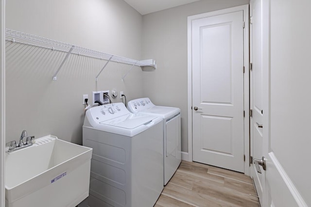 13509 SW Oceanus Blvd, Port Saint Lucie, FL 34987 - clothes washing area with washer and dryer and light wood-style floors