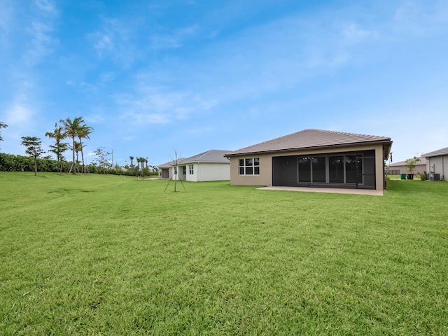 13509 SW Oceanus Blvd, Port Saint Lucie, FL 34987 - back of house with a lawn, a sunroom, stucco siding, and a tile roof